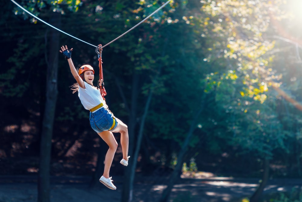 Young woman on a zip line at Wisp Resort near our Deep Creek Lake Hotel